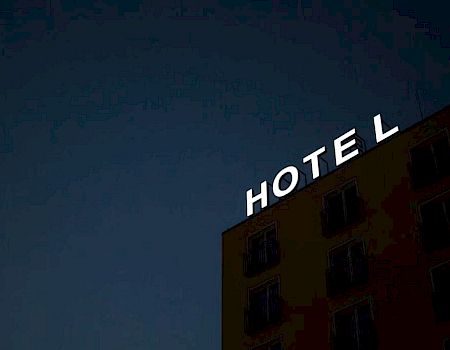 The image shows a building with a "HOTEL" sign at the top, with the letter "L" not fully attached or misaligned.